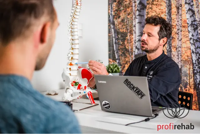 Grzegorz Skorus rozmawiający z pacjentem w swoim gabinecie Profirehab